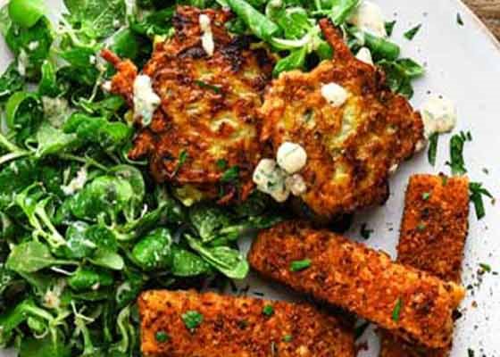 Ein Teller mit Brezel-Stäbchen mit Kartoffel-Zucchini-Puffer & Feldsalat