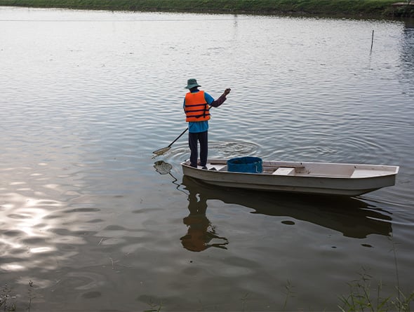 Person steht auf kleinem Boot in einem See
