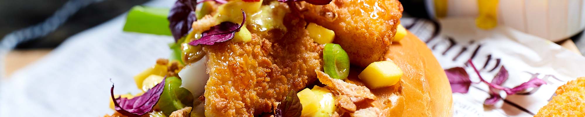 Fisch-Hot-Dog mit Mango, Ananas-Mayonnaise und Röstzwiebeln