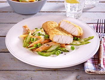 filegro traditioneller ofen backfisch auf bunten gemuesenudeln und rahmerbsen